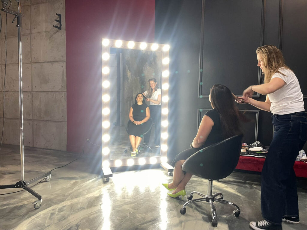 Model getting makeup done on set during a commercial photography production